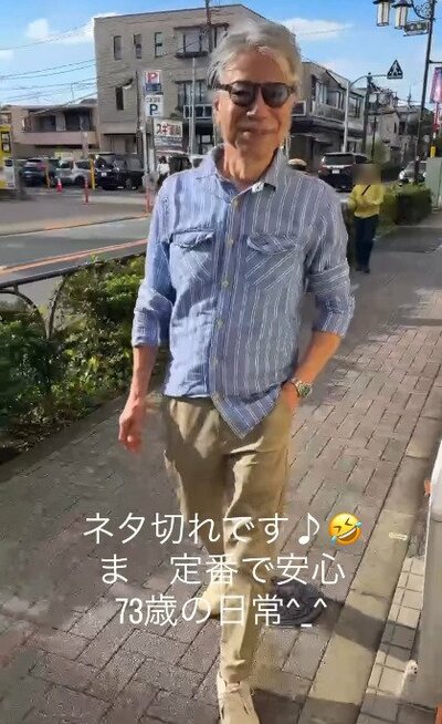 袖を少しまくったブルーのストライプシャツ