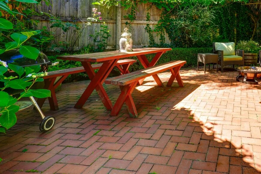 レンガ敷きのテラス。テーブルが一つ置かれている。