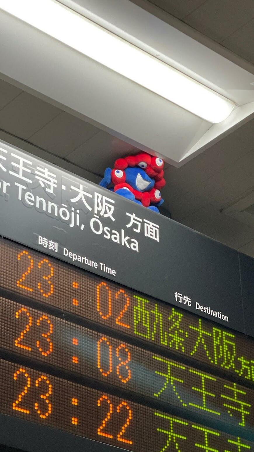 天井と電光掲示板の隙間に挟まるミャクミャク