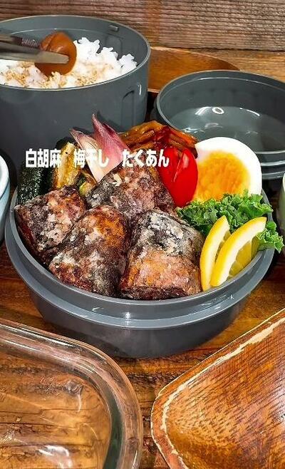 白胡麻をかけたご飯に、梅干しがのせられるところ