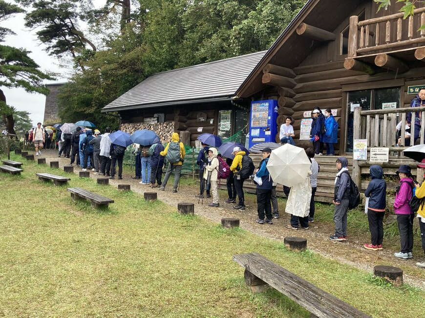 悪天候のなか山道に延びた長い列