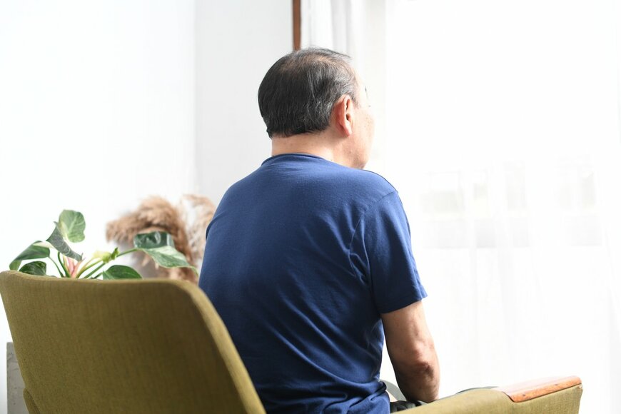 椅子に座っているアジア人の老人の背面図