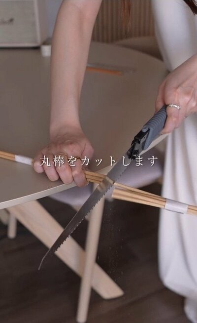 丸棒をのこぎりでカットしている様子