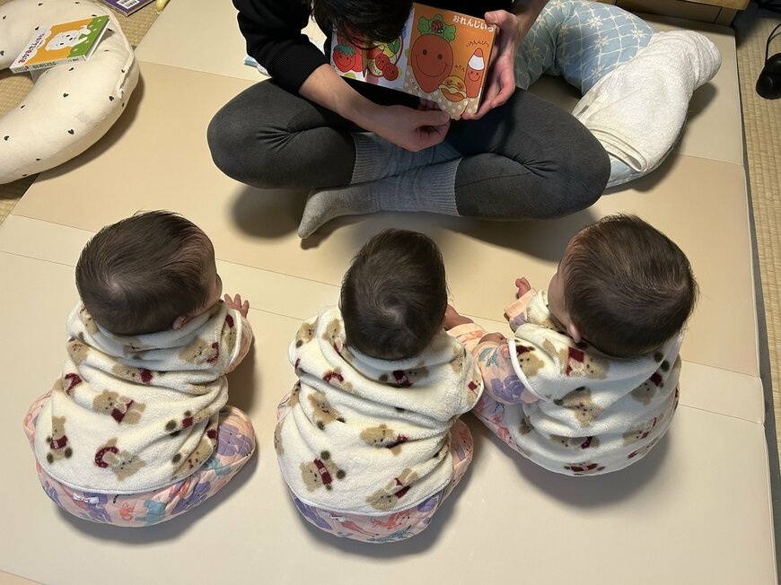 絵本に見入る三つ子ちゃん