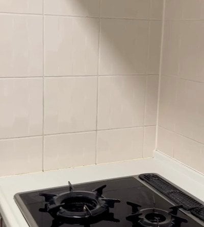 キッチンの白い壁にキャラメル色の「タイル柄シート」を貼るDIYアイデア。貼るだけの手軽さで、空間を海外風のおしゃれな雰囲気にガラリと変える実用的なリメイク術