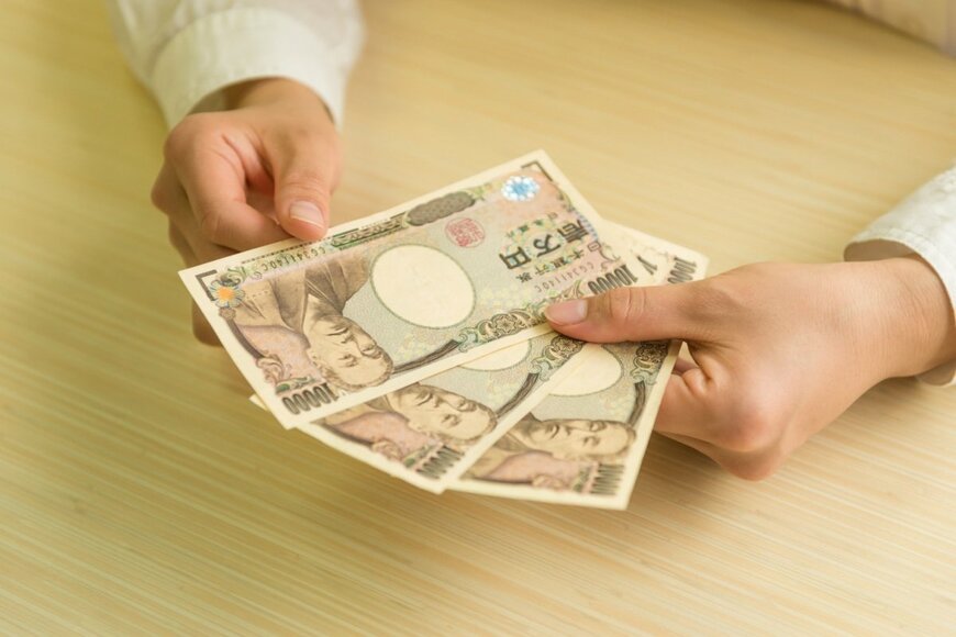 お金を数える手の写真