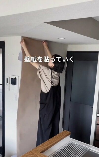壁にシール壁紙を貼っていく様子