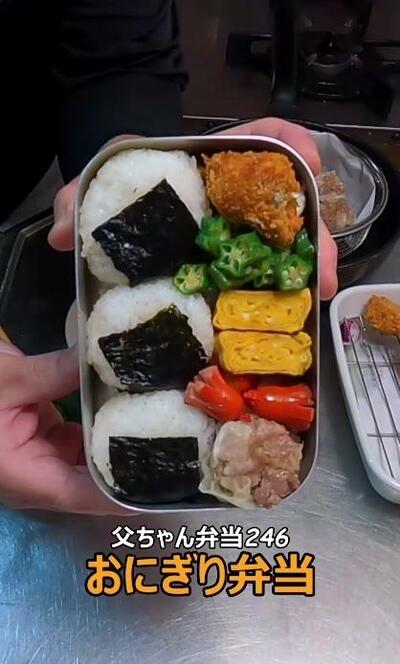 完成したおにぎり弁当を手に持って見せる
