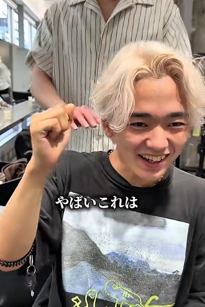嬉しそうに鏡で髪色をチェックする男性