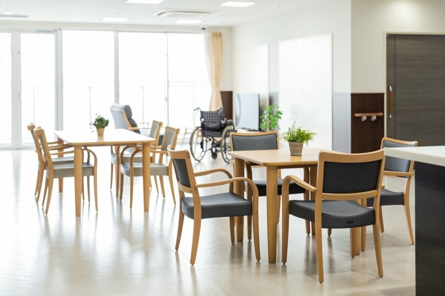 老人ホームの広間。テーブルとイスがある。