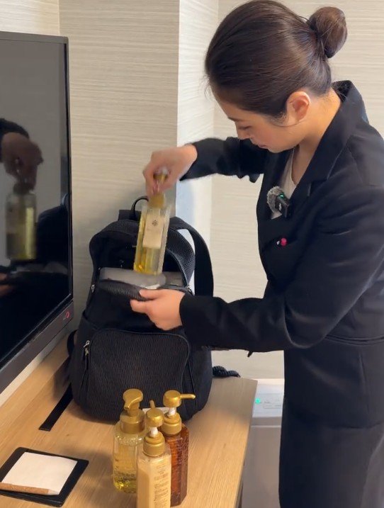 シャンプーのボトルをカバンに入れる様子