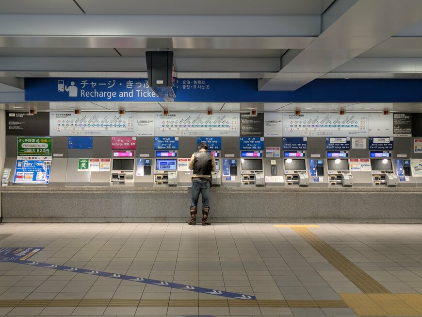 券売機で切符を買う夫