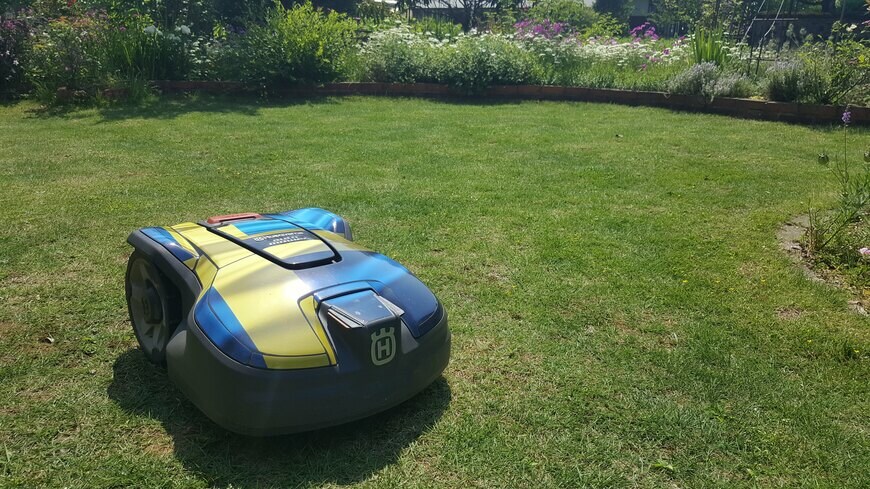 筆者の芝生の庭とロボット芝刈り機の写真