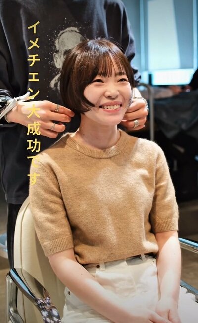 仕上がりを見て笑顔を見せる女性