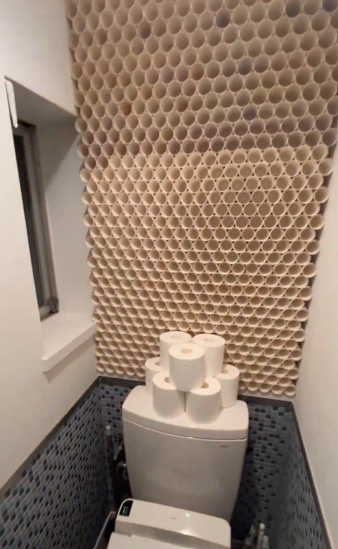 無数のトイレットペーパーに囲まれるトイレ
