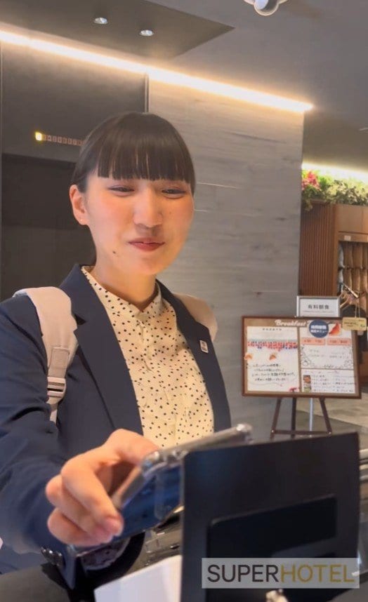 フロントで公式アプリをかざす様子