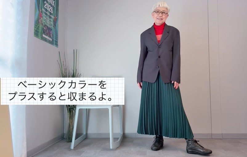 グリーンのプリーツスカートに赤のインナーを合わせたコーデ