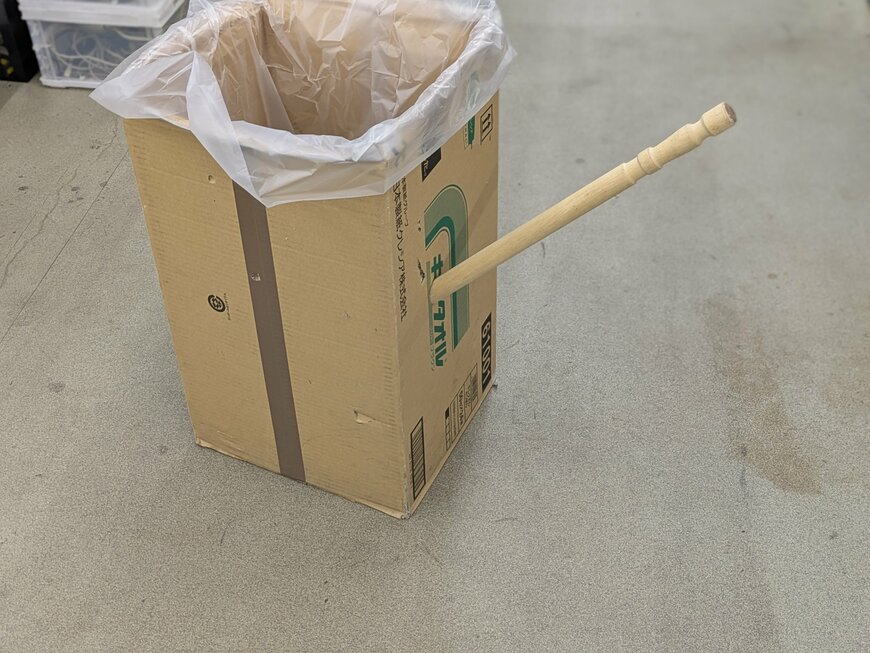 ダンボール箱に突き刺さった大きな爪楊枝