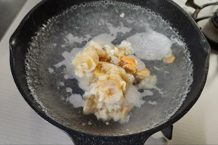 沸騰した水にホタテを投入している